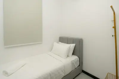 a bed with white sheets and pillows in a room at Neu Suites by COBNB in Kuala Lumpur
