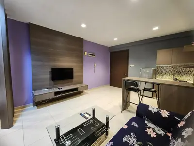 a living room with a couch and a kitchen at Regalia Suites KL Infinity Pool _ by MygeHomes in Kuala Lumpur