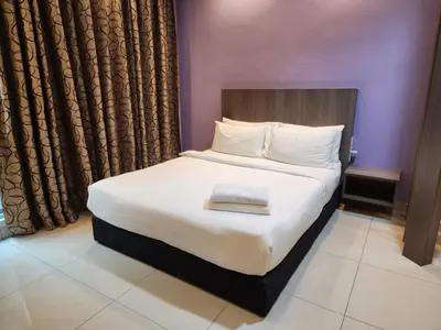 a bedroom with a large bed with white sheets at Regalia Suites KL Infinity Pool _ by MygeHomes in Kuala Lumpur