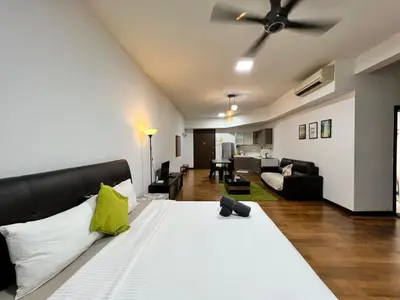 a bedroom with a large bed and a living room at Regalia Suites KL Infinity Pool _ by MygeHomes in Kuala Lumpur