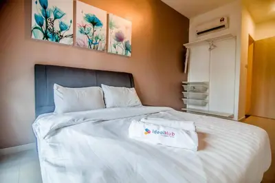 a bedroom with a white bed with two paintings on the wall at Legasi Kampung Baru - Idealhub in Kuala Lumpur