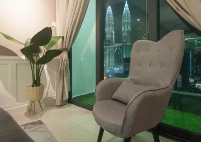 a chair in a room with a view of a city at Legasi Kampung Baru - Idealhub in Kuala Lumpur