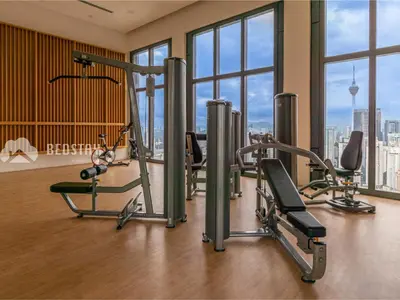 a gym with cardio equipment in a building with windows at Lucentia Residence BBCC By Bedstay in Kuala Lumpur