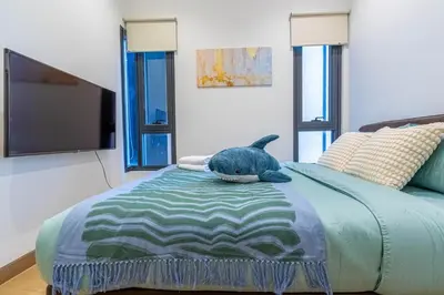 a blue cat laying on a bed in a room at Lucentia Residence BBCC By Bedstay in Kuala Lumpur