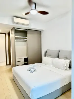 a bedroom with a white bed with a ceiling fan at Eaton Residences KLCC in Kuala Lumpur