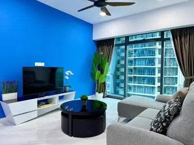 a blue living room with a couch and a tv at Eaton Residences KLCC in Kuala Lumpur