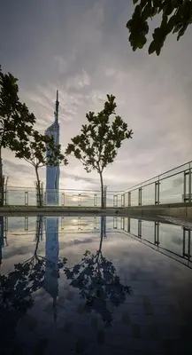 a reflection of a clock tower in a pool of water at S20- Bedroom Bukit Bintang Robertson with Netflix in Kuala Lumpur