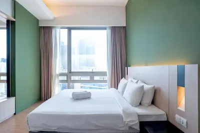 a bedroom with a white bed and a large window at SG Residence Bukit Bintang in Kuala Lumpur