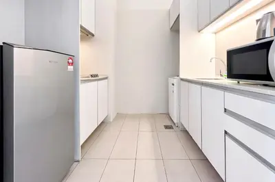a kitchen with white cabinets and a refrigerator at SG Residence Bukit Bintang in Kuala Lumpur