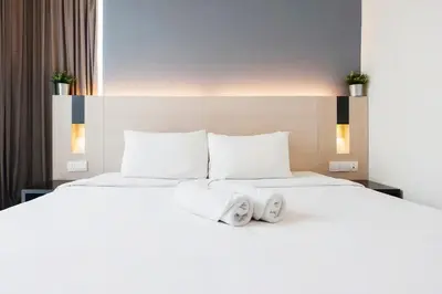 a bedroom with a large white bed with two pillows at SG Residence Bukit Bintang in Kuala Lumpur