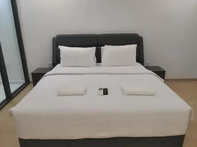 a large bed with white sheets and pillows at EATON RESIDENCE AT KLCC in Kuala Lumpur