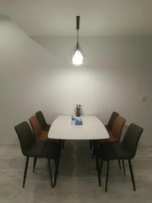 a white table with four chairs and a light at EATON RESIDENCE AT KLCC in Kuala Lumpur