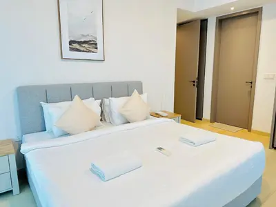 a bedroom with a large white bed with two towels on it at EATON RESIDENCE AT KLCC in Kuala Lumpur
