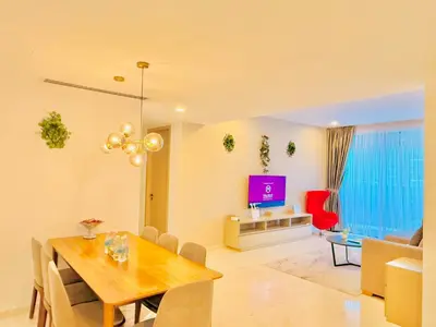 a dining room and living room with a table and a television at EATON RESIDENCE AT KLCC in Kuala Lumpur
