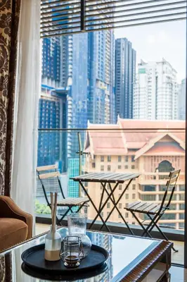 a table and chairs on a balcony with a view of a city at Dorsett Residence Kuala Lumpur 17 in Kuala Lumpur