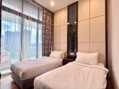 two beds in a hotel room with a window at Dorsett Residence Kuala Lumpur 17 in Kuala Lumpur