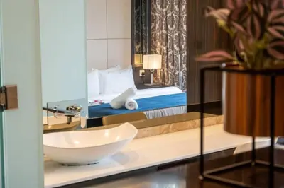 a bathroom with a sink and a bed and a mirror at Dorsett Residence Kuala Lumpur 12 in Kuala Lumpur