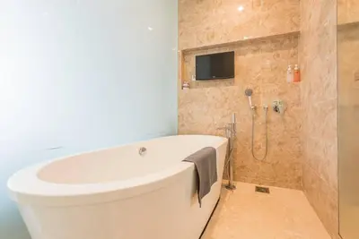 a bathroom with a tub and a tv on the wall at Dorsett residence Kuala Lumpur 19 in Kuala Lumpur