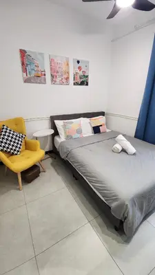 a bedroom with a bed and a yellow chair at The Nova by The City Collection in Kuala Lumpur