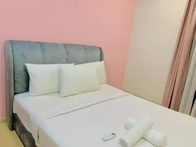 a bed with white sheets and pillows and a mirror at Star KLCC by Arman in Kuala Lumpur
