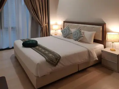 a bedroom with a large white bed with two lamps at Star KLCC by Arman in Kuala Lumpur