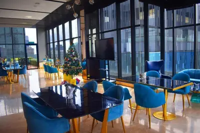 a restaurant with blue chairs and tables and a christmas tree at Star KLCC by Arman in Kuala Lumpur