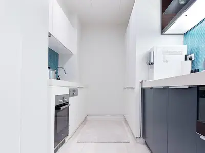 a white kitchen with white counters and a sink at Tropicana The Residence Onebedroom suite by VVHOMESTAY in Kuala Lumpur