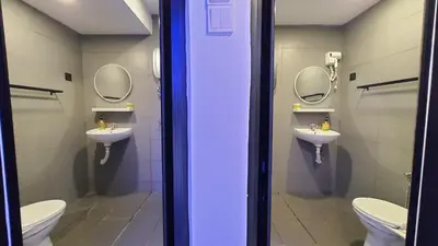 a bathroom with two sinks and two toilets with mirrors at A Place Like Home Landed House Kuala Lumpur in Kuala Lumpur
