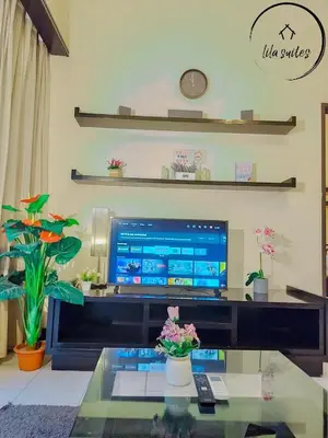a living room with a tv and a glass table at Lila Suites Seri Bukit Ceylon in Kuala Lumpur