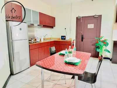 a kitchen with a red table and a refrigerator at Lila Suites Seri Bukit Ceylon in Kuala Lumpur