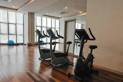 a gym with a row of exercise bikes in a room at MyRehat Regalia Residences in Kuala Lumpur