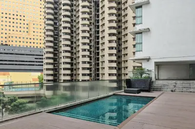 a swimming pool in front of a tall building at MyRehat Regalia Residences in Kuala Lumpur