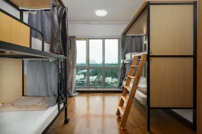 a room with bunk beds with a ladder and a window at MyRehat Regalia Residences in Kuala Lumpur