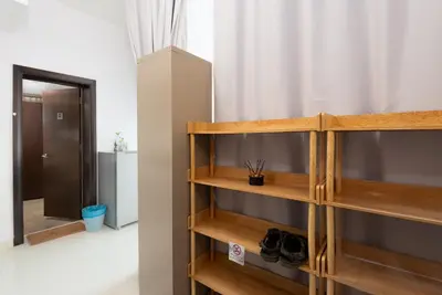 a room with a wooden shelf with shoes on it at MyRehat Regalia Residences in Kuala Lumpur