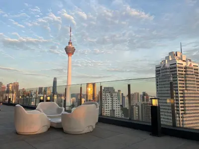 a balcony with chairs and a view of a city at Anggun KL Malaysia in Kuala Lumpur