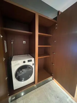 a washer and dryer in a room with wooden cabinets at Anggun KL Malaysia in Kuala Lumpur