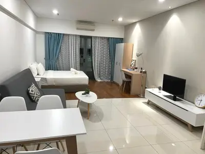 a living room with a bed and a tv in it at Summer Suites KLCC By Whollmark in Kuala Lumpur