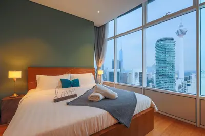 a bedroom with a bed with a large window at Calm Sojourn, Sky Suites KLCC in Kuala Lumpur