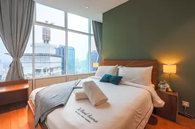 a bedroom with a large bed with a large window at Calm Sojourn, Sky Suites KLCC in Kuala Lumpur
