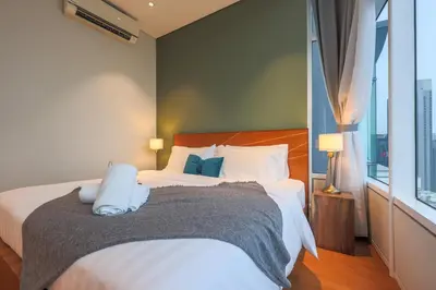 a bedroom with a bed and a large window at Calm Sojourn, Sky Suites KLCC in Kuala Lumpur