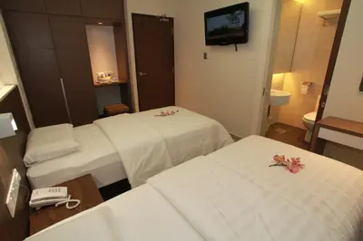a hotel room with two beds with flowers on them at Tai Ichi Hotel Kuala Lumpur in Kuala Lumpur