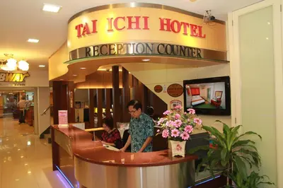 a woman standing at a reception counter in a hotel at Tai Ichi Hotel Kuala Lumpur in Kuala Lumpur