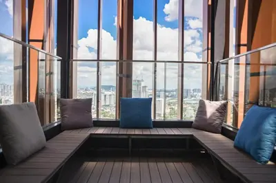 a balcony with pillows and a view of the city at Maxhome Cozy at Lucentia Bukit Bintang City Centre KL in Kuala Lumpur