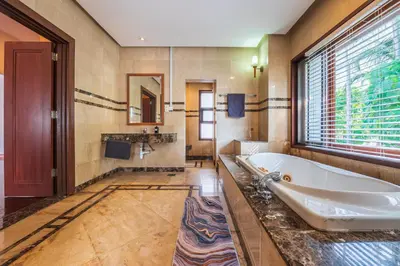 a bathroom with a tub and a large window at Tropical Bliss Luxe 5BR 30Pax Private Pool Villa KL by Verano in Kuala Lumpur