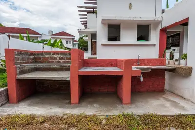 a red bench sitting on the side of a building at Tropical Bliss Luxe 5BR 30Pax Private Pool Villa KL by Verano in Kuala Lumpur