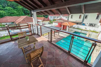 a balcony with a table and chairs and a pool at Tropical Bliss Luxe 5BR 30Pax Private Pool Villa KL by Verano in Kuala Lumpur