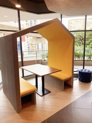 a table and a bench in a room with windows at The Nova by The City Collection in Kuala Lumpur