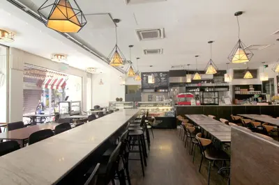 a restaurant with long tables and chairs and lights at Pacific Express Hotel Central Market Kuala Lumpur in Kuala Lumpur