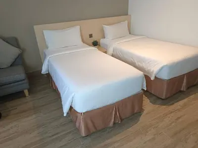 two twin beds in a room with a couch at Pacific Express Hotel Central Market Kuala Lumpur in Kuala Lumpur