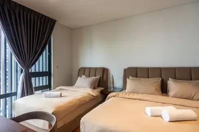 two beds in a room with a window at MyRehat Anggun Residences in Kuala Lumpur